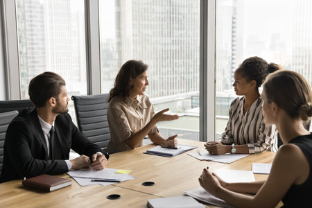 Group of multiethnic businesspeople met in conference room in high-rise office, discuss strategy, making decision related to optimizing their company operations, review key challenges, search solutionの写真素材