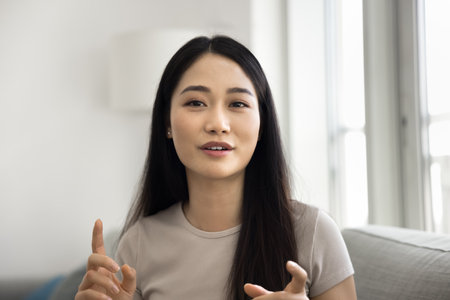 Head shot portrait, woman lead on-line talk using videocall application, sit on sofa and speaking, provide information, pass job interview remotely. Videoconference app, global worldwide communicationの写真素材