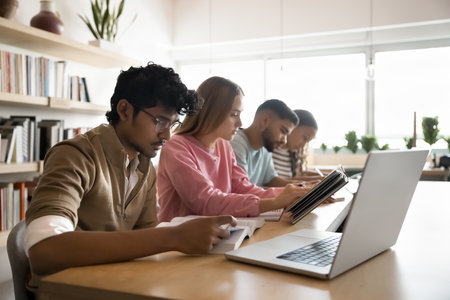 Serious students studying at table in classroom, read books, writing notes, make assignment, take part in exam preparation gathered together in campus library. Education, knowledge, professional skillの写真素材