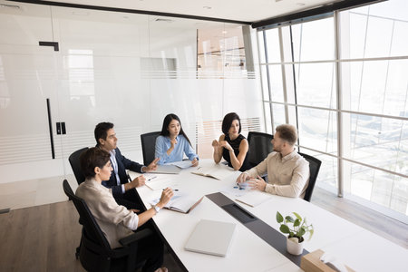 Creative brainstorming. Diverse multicultural managers executives entrepreneurs group gather around table in modern corporate office to collaborate on business project development make team decisionsの写真素材