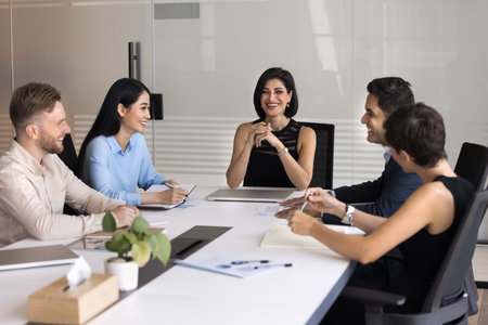 Supportive leadership. Smiling middle aged female leader boss ceo gather diverse multicultural corporate team around meeting table hold briefing conference in relaxed inclusive professional atmosphereの写真素材