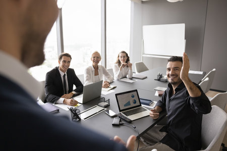 Engaged participation is welcome. Over shoulder view business coach leader interact with diverse businesspeople group on meeting seminar at conference room encourage trainees raise hands ask questionsの写真素材