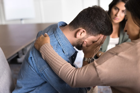 Social community member provide psychological support to participant, touch his shoulder as empathetic gestures, showing care and help, give hope, guidance, and encouragement in hard life situationsの写真素材