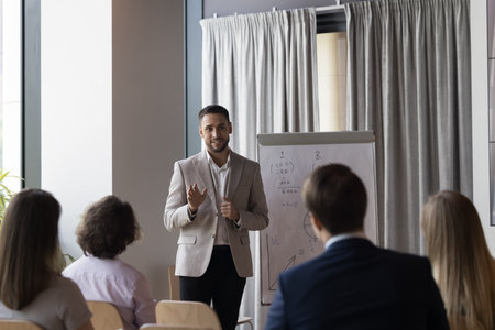 Rear view group of businesspeople listens speech of confident man team leader business coach during...