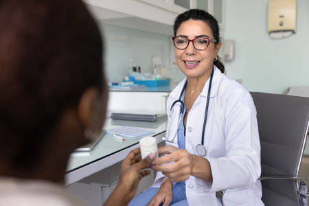 Happy practitioner doctor giving bottle of pills to female patient, prescribing medication, painkiller, smiling, recommending food supplement for successful therapyの写真素材