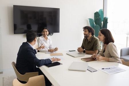 Positive, friendly teammates take part in briefing, laughing, enjoy pleasant conversation, discussion of creative business-related ideas, share solution, exchanging opinions at seminar in meeting roomの写真素材