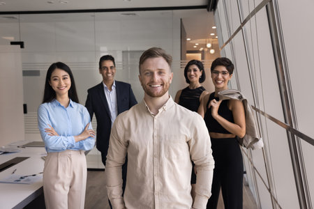 Five diverse young and mature ambitious teammates, corporate staff members posing in office, look at camera, exuding leadership and professionalism, feel satisfied with career growth and joint successの写真素材