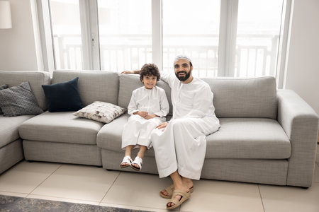 Muslim parenting with love and tradition. Happy smiling young Arab father little school age boy son...