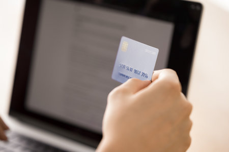 Close up shot person client hand hold credit card before notebook screen. Ecommerce online shopping digital payment security mobile bank paying for subscription services financial transaction conceptの写真素材