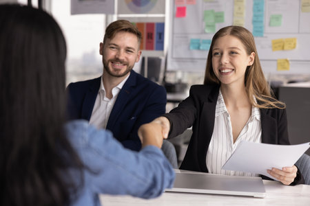 Happy employer company managers shaking hands with hired job candidate after interview meeting,...