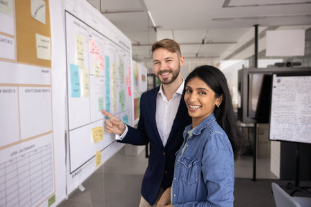 Happy attractive millennial business man and woman working on project management at Kanban scrum...