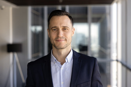 Positive confident young Latin business leader man in formal jacket head shot. Successful Hispanic...