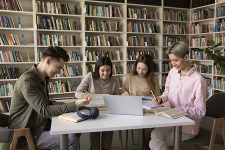 Collaborative research and note taking. Busy young diverse students zoomers gather around table in...