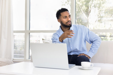 Problem solving at freelance work. Serious pensive gen z man freelancer work online on notebook from...