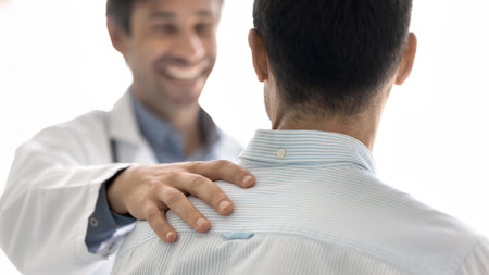 Friendly medical support. Close up shot happy doctor touch male patient shoulder. Delivering good news with warmth empathy celebrating recovery emotional bonding between physician sick person conceptの写真素材