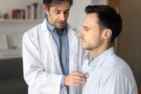 Regular cardio diagnostics for men. Middle aged male patient receiving cardiovascular exam by family...