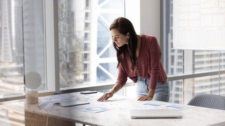 Latina businesswoman engaged in strategic planning, make financial data analysis, reviewing charts...