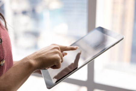 Close up, female analyzing diagrams, reviewing data and metrics on digital tablet, engaged in...