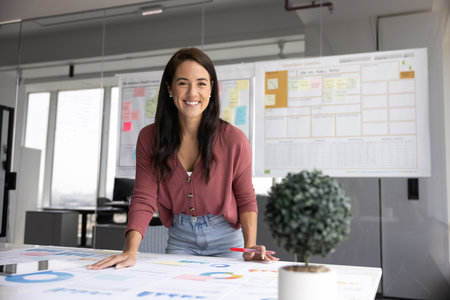 Portrait of professional woman, financial consultant or project manager working with charts, graphs,...