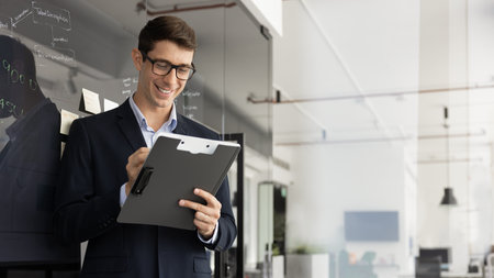 Positive young business project leader man analyzing document, financial report, marketing research...