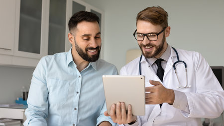 European qualified medical worker showing medical test, x-ray or MRI scans results on digital tablet...