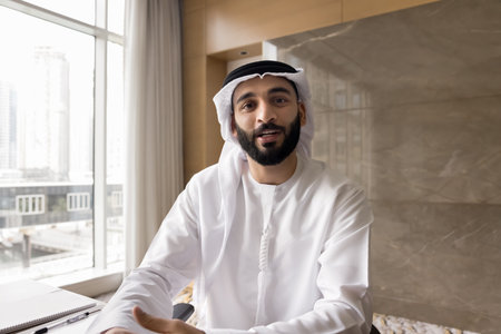 Remote business communication. Webcam view portrait confident Arabian businessman coach trainer in traditional white robe talk by videocall in conference app speak present idea online at virtual eventの写真素材