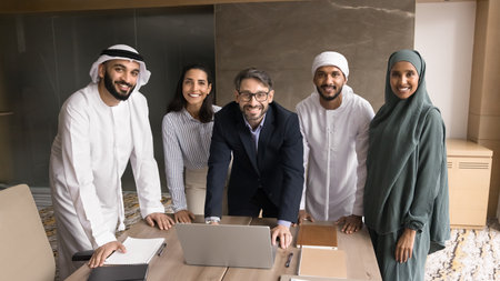 Successful and motivated. Portrait happy smiling business leader and multicultural corporate team confident professor and diverse students group standing at boardroom using notebook looking at cameraの写真素材
