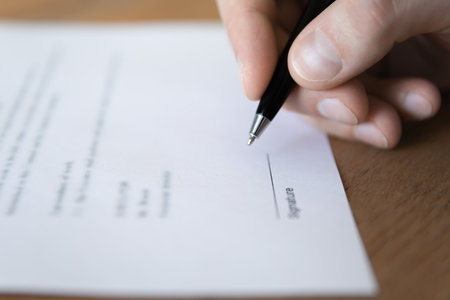 Sign business paper. Close up ballpoint pen in male hand for official document signing. Employment...