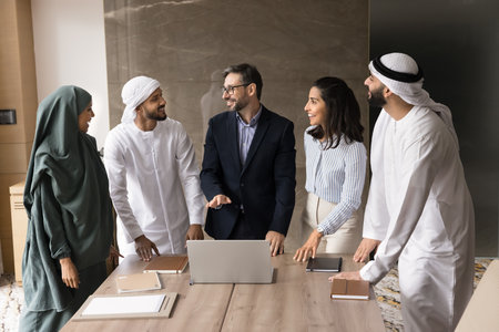 Group mentoring. Confident young adult man in formal suit team leader teacher explain project offer idea give knowledge to multiethnic workers students interns on workshop seminar at office boardroomの写真素材