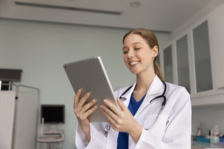 Happy woman doctor videocalling to patient, working online, provide professional medical assistance to clinic client using digital tablet device and modern platform or application. Healthcare servicesの写真素材