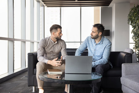 Business dialogue. Focused young man insurance agent legal advisor financial consultant talking with...