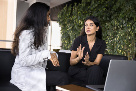 Collaborative discussion. Two diverse multiracial young businesswomen partners colleagues engaged in...
