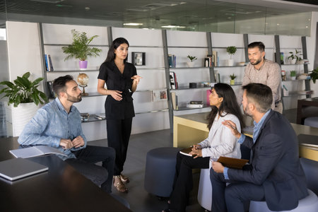 Spontaneous brainstorm. Multiethnic businesspeople employees executives group use pause in work for informal meeting discuss problem solution on workday break think on strategy express business ideasの写真素材