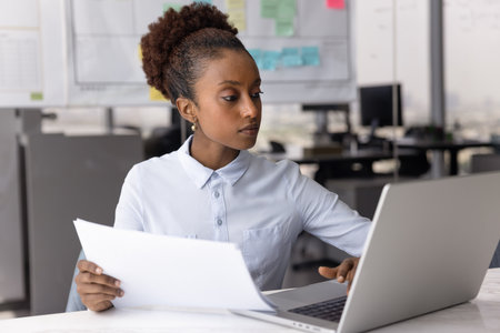 Data analysis. Busy young woman employee manager accountant work with digital tools paper reports at...