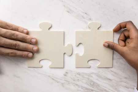 Cooperation guide to success. Cropped close up hands of two young people from diverse ethnicities...