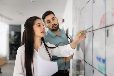 Business coaching and modern planning tools. Smart young businesswoman project manager team leader...