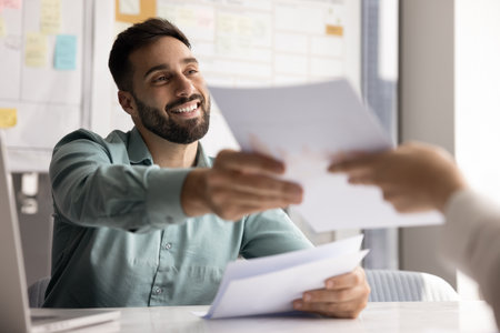 Confident male business professional sales specialist finance advisor consult client on meeting in office explain project share information in printed paper documents present offer draft to discussの写真素材