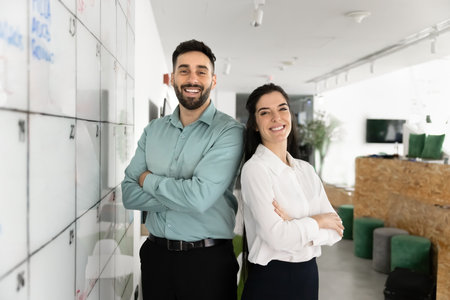 Confident professionals. Successful business team of two diverse millennial colleagues pose for...