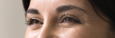 Look into future. Close up cropped portrait expressive smiling eyes beautiful young woman gaze forward. Clear sharp vision strong eye health optical care concept. Wide banner shot for website headerの写真素材