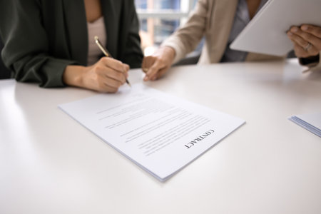 Hand of businesswoman pointing at place for signature in document for business partner, client,...