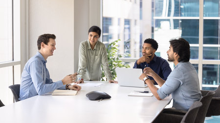 Work meeting. Diverse group of multicultural businesspeople startup developers software engineers creative project founders gather for workshop seminar share ideas discuss strategy at modern boardroomの写真素材