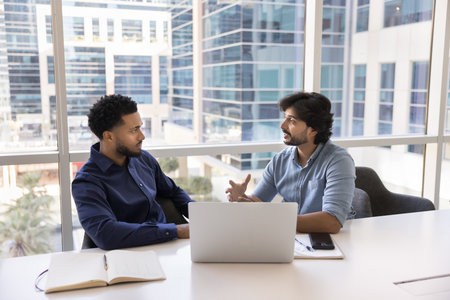 Mentor and intern. Matured skilled male business professional share experience insights with focused millennial guy offer advice on technical task with notebook pc explain project management strategyの写真素材