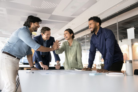 Respect for bright insight. Friendly mature man team leader startup coordinator unite hands in high five with happy young woman worker colleague agree with idea support plan creating project in groupの写真素材