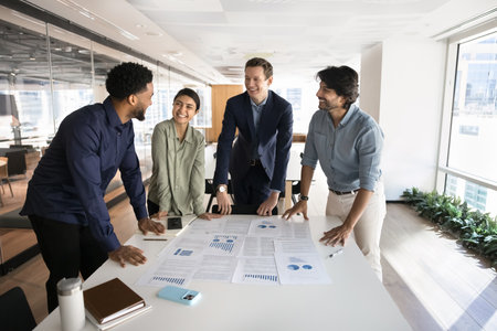 Moment of business joy. Laughing multicultural businesspeople team social media marketers data...