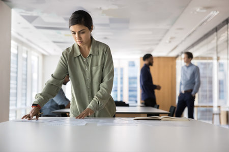 Engaged in paperwork. Busy millennial woman financial analyst corporate executive thinking on statistic information at workplace study sales growth forecast trading results plan investment. Copy spaceの写真素材