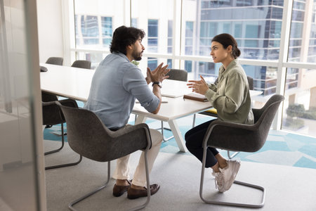 Negotiation dialogue. Two diverse colleagues or young woman manager consultant mature man client customer hold conversation discuss life insurance loan sales agreement details at modern agency officeの写真素材