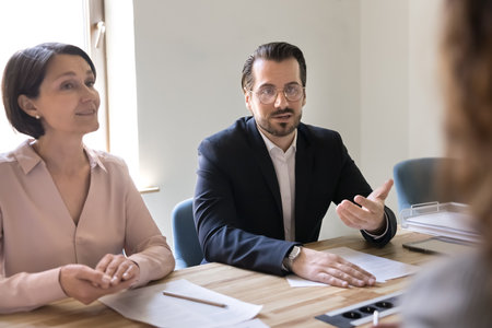 Discussing contract. Confident millennial male business expert executive lawyer speak to partners...