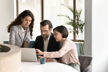 Brainstorming and collaboration. Three diverse business professionals work together on digital...