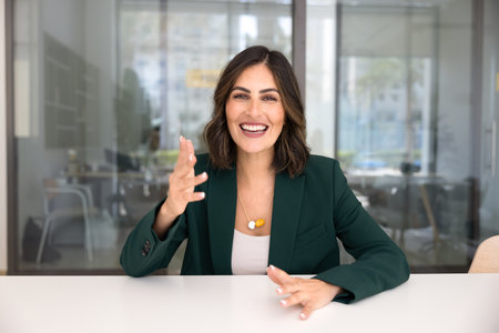 Cheerful young business professional woman talking on video conference call, speaking and smiling at camera, moving hands, laughing, enjoying online communicationの写真素材