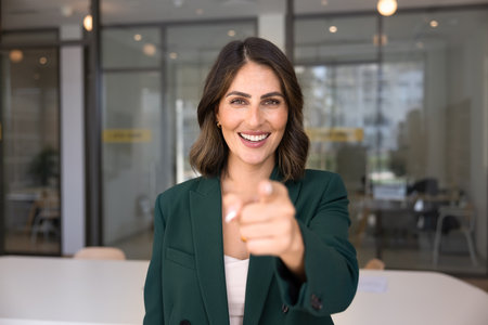 Happy young Latin businesswoman pointing finger at camera, making we need you gesture of choice, offering hiring, cooperation, internship, Positive Hispanic business professional choosing youの写真素材